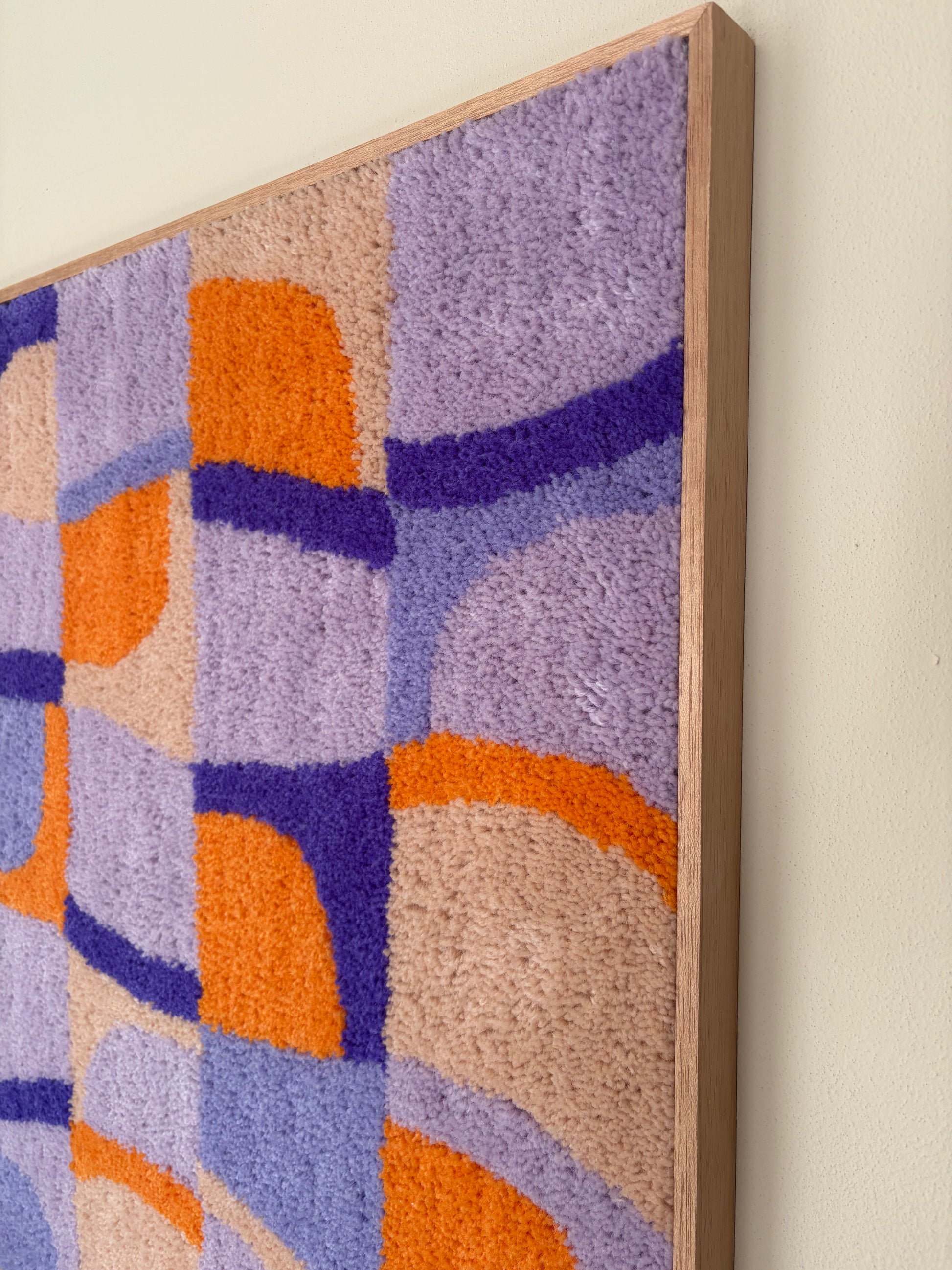 Discover a playful rhythm with Sundial Checker. Soft lavender, warm amber and sandy beige blocks interlock in a hand-tufted grid, where curved sun-like forms break through the geometry — bringing warmth and movement to a modern interior.

Handcrafted Tufted Art This piece is 100% hand-tufted using premium New Zealand wool, chosen for its rich texture, natural luster and durability. Every curve and colour block is tufted by hand, giving the surface a soft, tactile depth that a printed piece simply can't repl